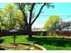 Spacious backyard with a large tree, brick-lined flower beds, and well-maintained lawn at 11823 Williams Way, Northglenn, CO 80233