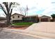 Charming split level home features a manicured lawn, brick accents, and a detached two car garage at 11823 Williams Way, Northglenn, CO 80233