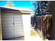 A detached single-car garage with a white exterior, alongside a wooden fence at 11823 Williams Way, Northglenn, CO 80233