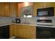 Traditional eat-in kitchen featuring light wood cabinetry, white countertops, and modern black appliances at 11823 Williams Way, Northglenn, CO 80233