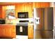 Well-lit kitchen with warm wood cabinets, black appliances, and a stainless steel refrigerator at 11823 Williams Way, Northglenn, CO 80233