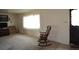 Cozy living room featuring a rocking chair near a bright window and a view of the front door at 11823 Williams Way, Northglenn, CO 80233