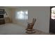 Cozy living room with a rocking chair and large windows for natural light at 11823 Williams Way, Northglenn, CO 80233