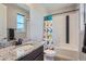 Charming bathroom featuring a shower-tub combo and granite sink top at 7994 S Kewaunee St, Aurora, CO 80016