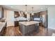 Spacious kitchen showcasing a center island, stainless steel appliances, stylish countertops, and dark cabinets at 7994 S Kewaunee St, Aurora, CO 80016
