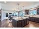 Modern kitchen featuring an island, stainless steel appliances, granite countertops and sleek dark cabinets at 7994 S Kewaunee St, Aurora, CO 80016