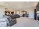 Spacious living room with open floor plan into kitchen and foyer, featuring plush carpeting and neutral paint at 7994 S Kewaunee St, Aurora, CO 80016