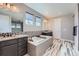 Elegant main bathroom with soaking tub, dual sinks with granite countertops, and tiled floors at 7994 S Kewaunee St, Aurora, CO 80016