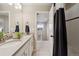 Bright bathroom with dual sinks, quartz counters, and a tiled shower and floors at 16400 Alberta Dr, Parker, CO 80134