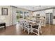 Elegant dining area with a dark wood table, white chairs, and sliding glass doors to the backyard at 16400 Alberta Dr, Parker, CO 80134