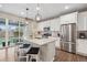 Bright kitchen featuring stainless steel appliances, an island with seating, and sliding glass doors at 16400 Alberta Dr, Parker, CO 80134
