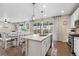 Modern kitchen island with pendant lighting, seating, and open views to the dining and living areas at 16400 Alberta Dr, Parker, CO 80134