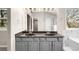 Bathroom featuring double sinks with gray cabinets and large mirror, providing ample space and modern style at 3205 S Tulare Ct, Denver, CO 80231