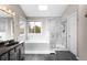 A luxurious bathroom featuring a soaking tub, a glass-enclosed shower, and marble tile at 3205 S Tulare Ct, Denver, CO 80231