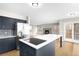 Modern kitchen with sleek island, stainless steel appliances and an adjacent dining area at 3205 S Tulare Ct, Denver, CO 80231