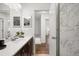 Bathroom featuring a vanity, large mirror, and a shower with a marble surround at 670 Winona Ct # 38, Denver, CO 80204