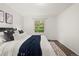 Bright bedroom featuring a queen bed with hardwood floors and a window view at 670 Winona Ct # 38, Denver, CO 80204