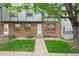 Charming townhome exterior with brick facade, green lawn, and mature tree at 670 Winona Ct # 38, Denver, CO 80204