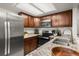 Kitchen with stainless steel appliances, granite countertops, and dark-wood cabinets at 670 Winona Ct # 38, Denver, CO 80204