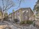 Condominium building with stone and wood facade and landscaping with trees and rocks at 4400 S Quebec St # M-204, Denver, CO 80237