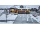 Inviting home with a three-car garage, stone accents, and a cozy front porch on a snowy day at 1060 Arrowhead Ct, Erie, CO 80516