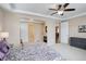 Bright main bedroom showcasing a ceiling fan and a doorway to the ensuite bath and fireplace at 1060 Arrowhead Ct, Erie, CO 80516