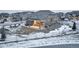 Rear exterior view with a backyard patio with a table and chairs surrounded by snow at 1060 Arrowhead Ct, Erie, CO 80516