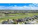 Aerial view of a green golf course community with houses and streets under a bright blue sky with scattered clouds at 11748 Mill Valley St, Parker, CO 80138