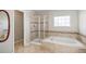 Bathroom featuring shower with glass doors and soaking tub with tile surround at 11748 Mill Valley St, Parker, CO 80138