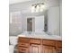 Bathroom featuring double sinks, vanity with wood cabinets, and well-lit mirror at 11748 Mill Valley St, Parker, CO 80138