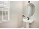 Pedestal sink with stylish round mirror near a window offers natural light at 11748 Mill Valley St, Parker, CO 80138