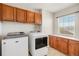 Functional laundry room with built-in cabinets, countertop space, large window and washer and dryer at 11748 Mill Valley St, Parker, CO 80138
