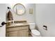Well-lit powder room featuring neutral walls, granite countertops, and a round mirror at 6762 Eagle Pl, Highlands Ranch, CO 80130