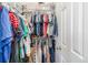 Walk-in closet with clothes hanging on rods and plastic bins for storage at 19884 E Villanova Pl, Aurora, CO 80013