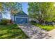 A blue home featuring a two-car garage and driveway with shade trees on a sunny day at 19884 E Villanova Pl, Aurora, CO 80013