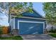 Close up of a blue two-car garage with brick features, a cement driveway and grass lawn at 19884 E Villanova Pl, Aurora, CO 80013