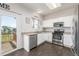 Bright kitchen features a stainless steel dishwasher, oven, microwave, and access to the backyard deck at 19884 E Villanova Pl, Aurora, CO 80013