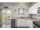 Bright kitchen features stainless steel appliances, modern white cabinets, and access to the backyard deck at 19884 E Villanova Pl, Aurora, CO 80013