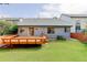 Large green backyard featuring a wood deck and the back of the house with a sliding glass door at 354 Willowick Cir, Highlands Ranch, CO 80129