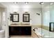 Bright bathroom featuring double sinks, granite countertops, dark wood cabinetry, and a soaking tub at 354 Willowick Cir, Highlands Ranch, CO 80129