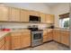 Well-lit kitchen featuring wood cabinets, stainless steel appliances, and a window above the sink at 354 Willowick Cir, Highlands Ranch, CO 80129