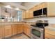 Well-appointed kitchen featuring stainless steel appliances, wood cabinets, and a pass-through to the living area at 354 Willowick Cir, Highlands Ranch, CO 80129