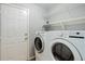 Convenient laundry room equipped with a washer, dryer, and shelving for storage at 354 Willowick Cir, Highlands Ranch, CO 80129
