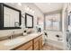Bright bathroom featuring dual sinks, soaking tub with view, and modern fixtures at 537 N 48Th Ave, Brighton, CO 80601