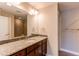 Bathroom featuring a granite countertop, wood cabinets, and a large mirror at 767 Robert St, Longmont, CO 80503