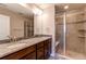 Primary bathroom featuring double sinks, granite countertop, tiled shower, and modern finishes at 767 Robert St, Longmont, CO 80503