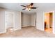 Neutral bedroom with ceiling fan, carpet and doorways to the bathroom and walk-in closet at 767 Robert St, Longmont, CO 80503