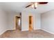 Bright bedroom with carpet flooring, ceiling fan, and multiple doorways at 767 Robert St, Longmont, CO 80503