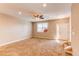 Open living room with neutral carpet, a ceiling fan, and a bright window overlooking the outdoors at 767 Robert St, Longmont, CO 80503