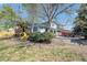 Spacious backyard featuring a playground with slide, fire pit, enclosed sunroom, and mature trees at 15962 E Lehigh Cir, Aurora, CO 80013